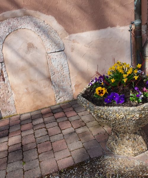 Blumenschale vor Kirche mit historischem Eingang